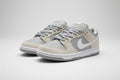 Pair of light gray and beige sneakers with a Nike logo on a white background