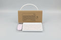 Wireless keyboard and mouse set with cardboard box on a light blue surface.