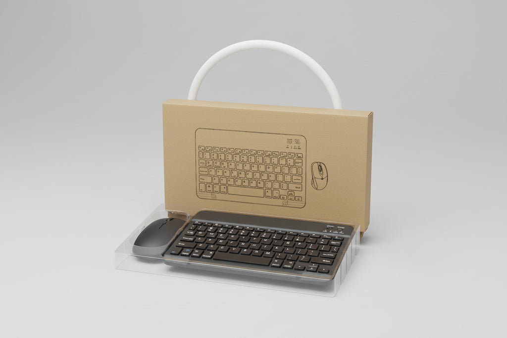 Cardboard cutout of a keyboard and mouse with a real keyboard and mouse on a surface.