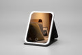 Lighted makeup mirror with control panel on a dark background