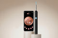 Ear inspection device with smartphone displaying ear view on beige background