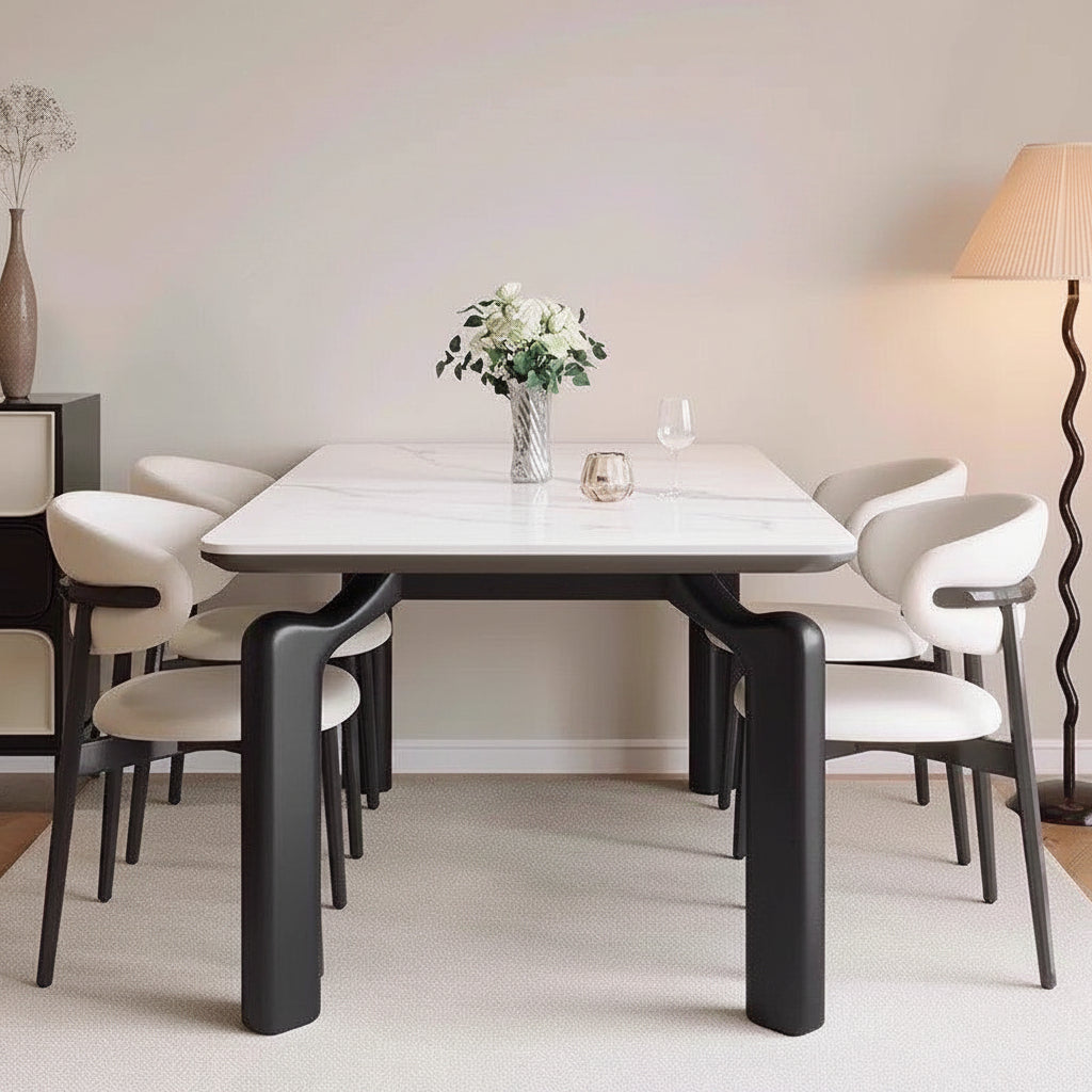 Dining table with black legs and white chairs in a room with text overlay.